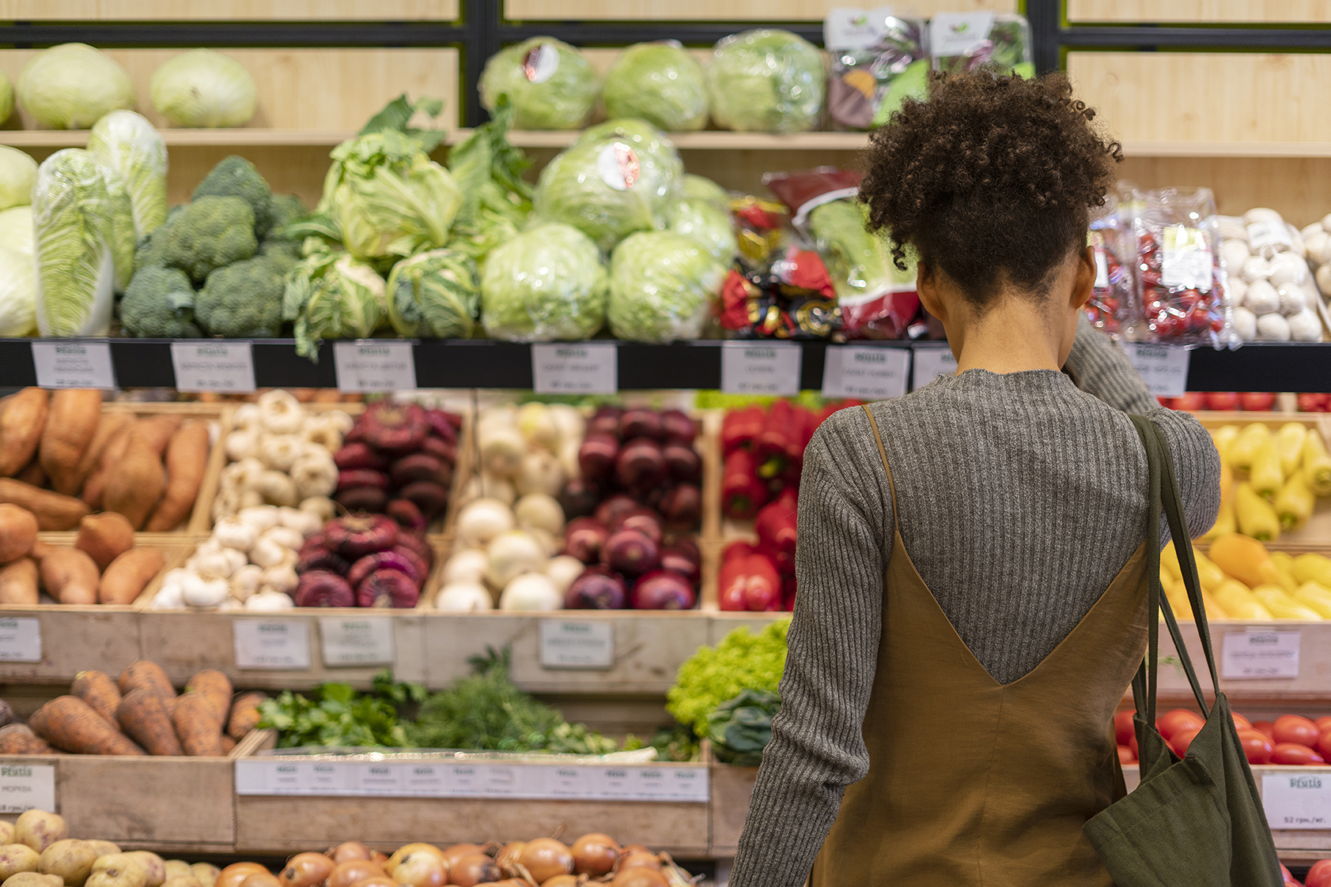 jeune femme devant un rayon de légumes